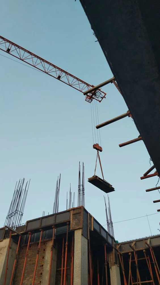 Tower crane lifting formwork at a construction site